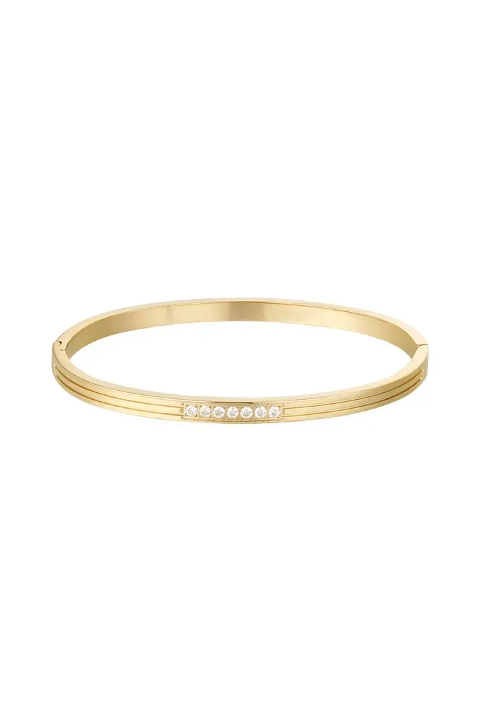 Een gouden armband met diamanten op een witte achtergrond.