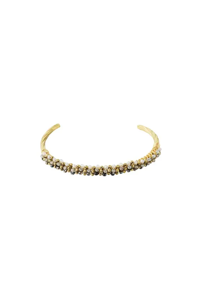 Een gouden armband met diamanten op een witte achtergrond.