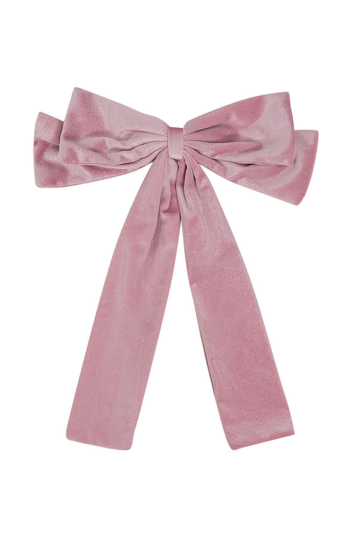 Een roze fluwelen strik op een witte achtergrond.