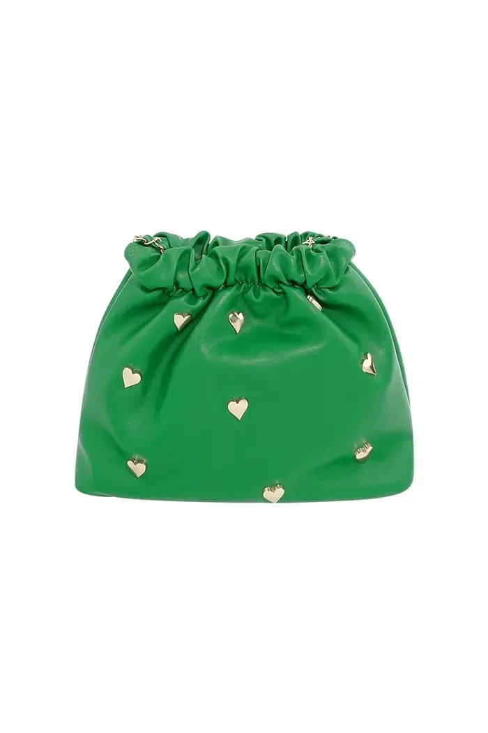 Een groene tas met witte hartjes erop op een witte achtergrond.