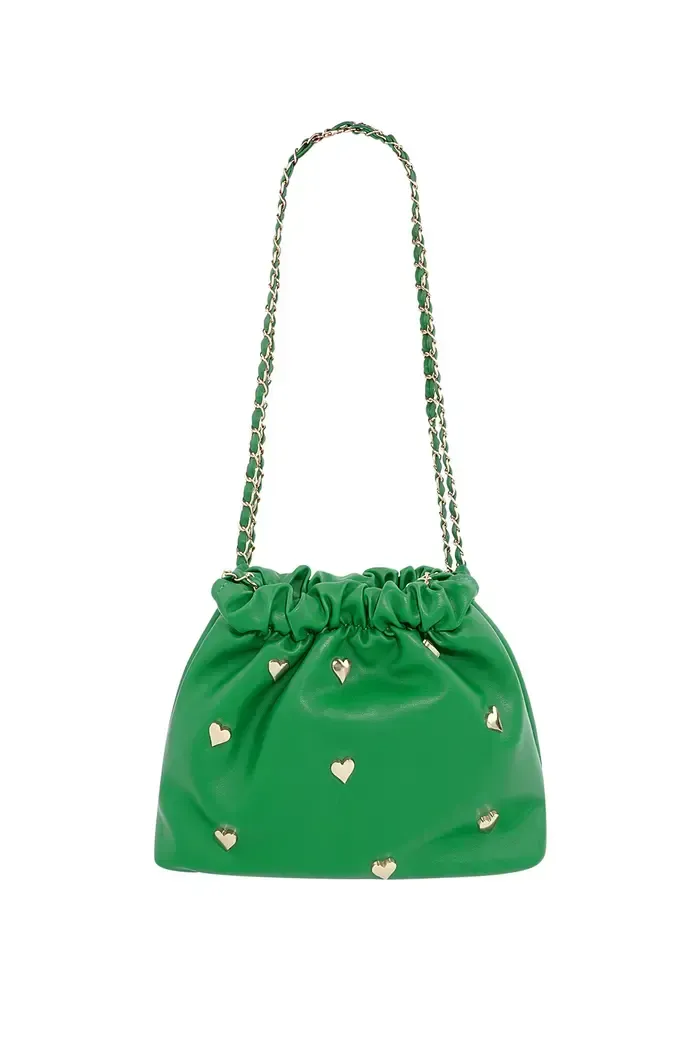 Een groene tas met witte hartjes erop op een witte achtergrond.