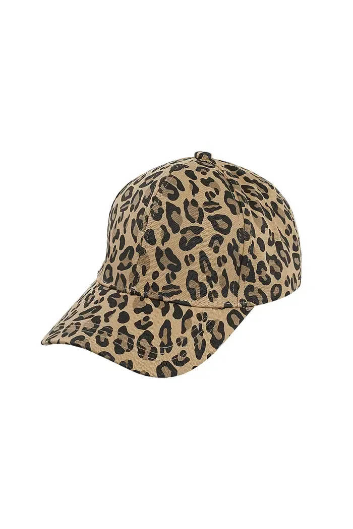Een vrouw met een baseballpet met luipaardprint en een grijs jasje.