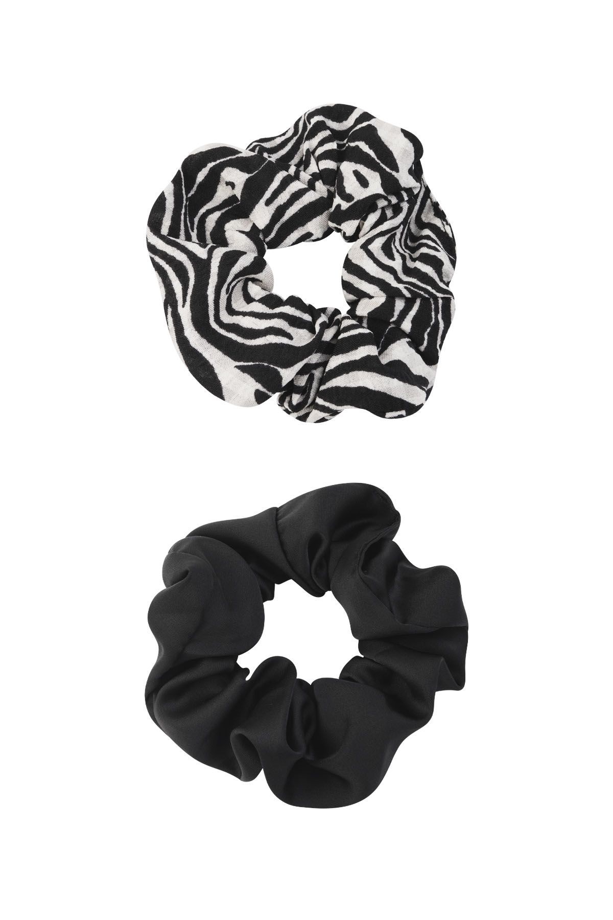 Een vrouw draagt onze zebra en  zwarte scrunchie.