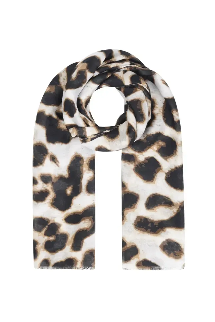 Een vrouw draagt ​​een luipaardprint vest en jeans.