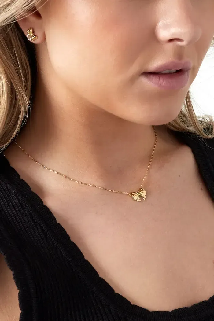 Een zilveren ketting met een vlinderhanger aan een ketting.