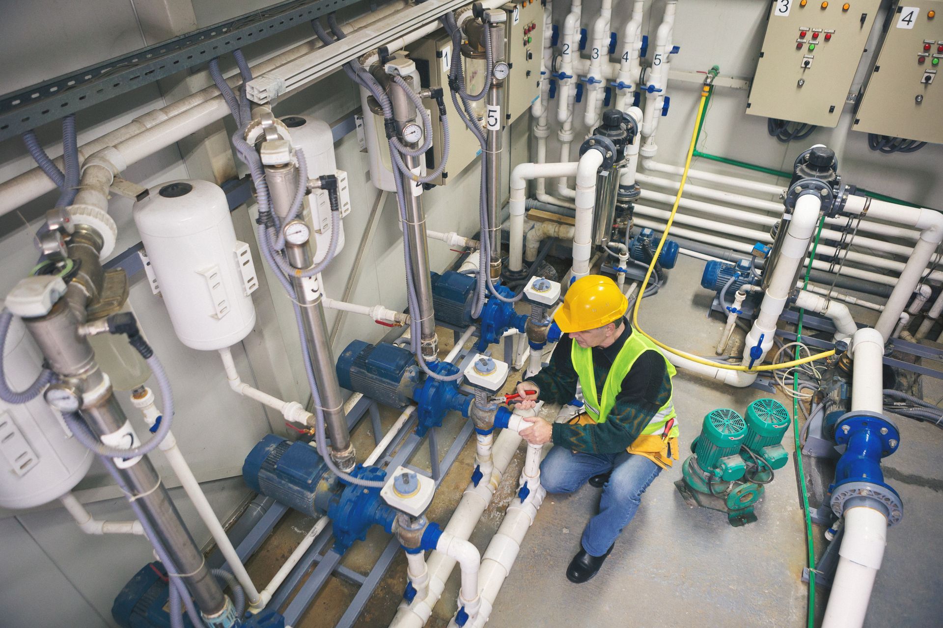 Technician repairing pipes in boiler room.