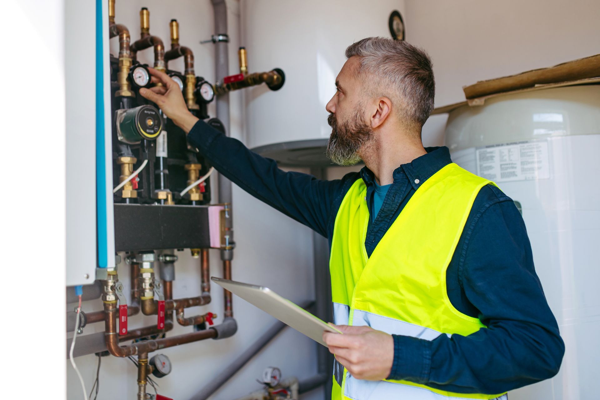 Technician inspecting circulation pumps for underfloor heating system.