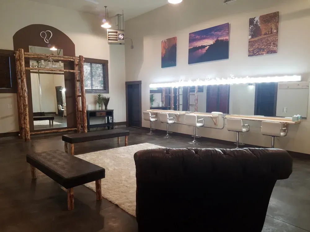 Modern salon interior with styling chairs, mirrors, benches, and wall art under bright lights