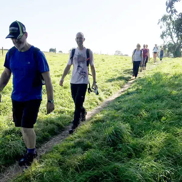A group of people walking across a field on a sunny day in Cheshire.