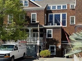 Brick townhouse entrance with a white van parked in front and an accessible ramp leading to the door