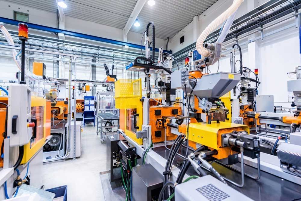 Industrial factory floor with orange and yellow machinery and robotic equipment in a bright production hall
