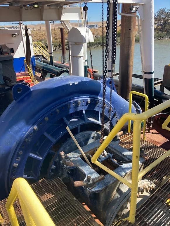 Blue industrial machinery with yellow railings on a metal platform outdoors