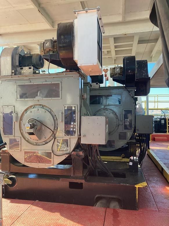 Large industrial machine with gauges and panels in a workshop, viewed from the front.