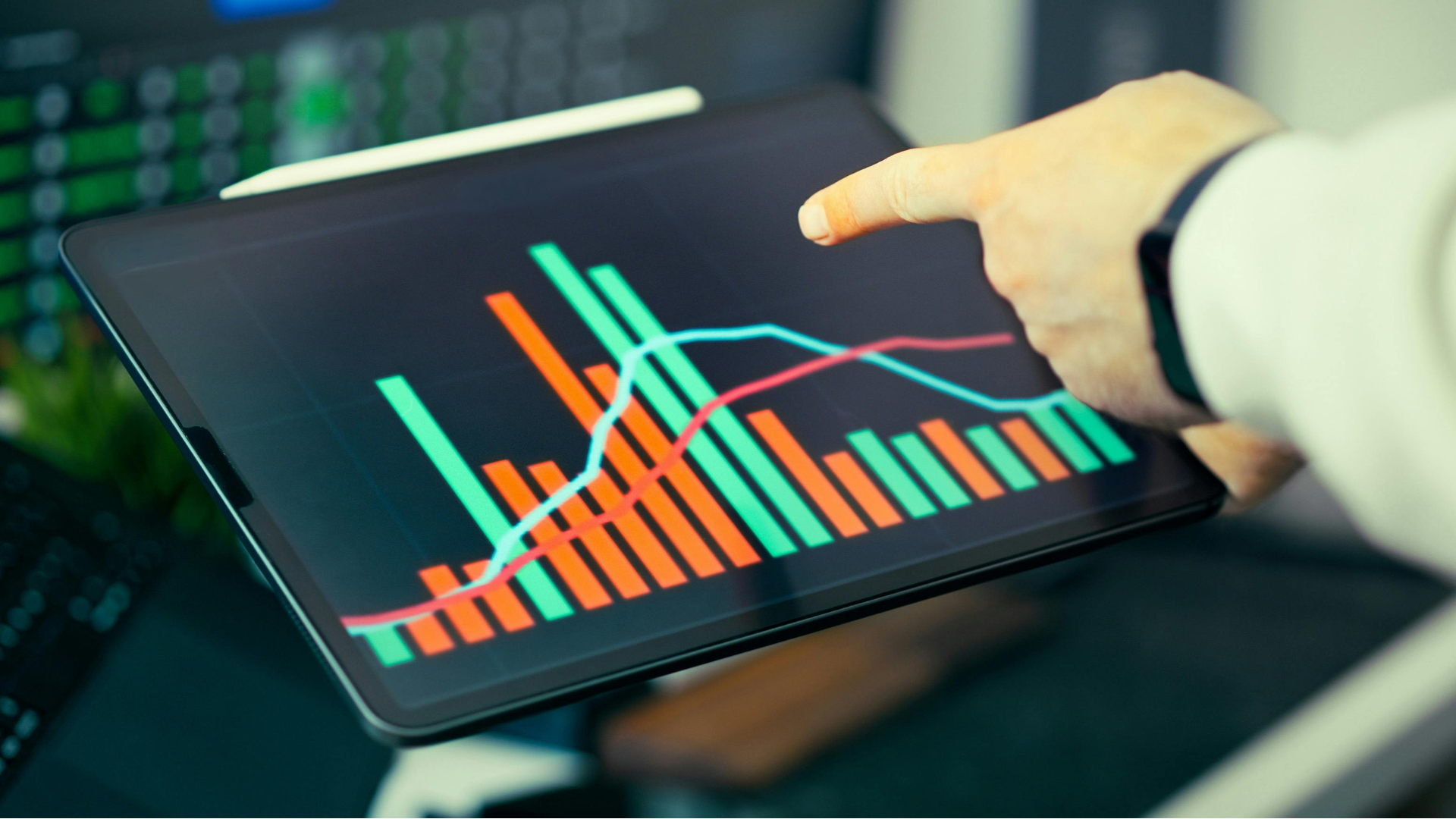 A tablet displaying a live event dashboard with graphs tracking attendee check-ins and session attendance numbers.