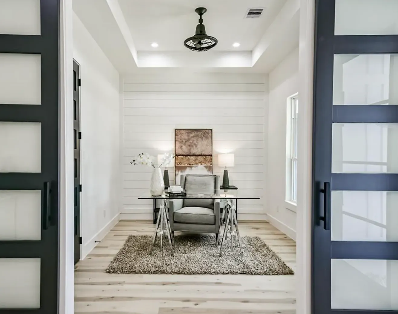 A room with sliding glass doors and a desk and chair