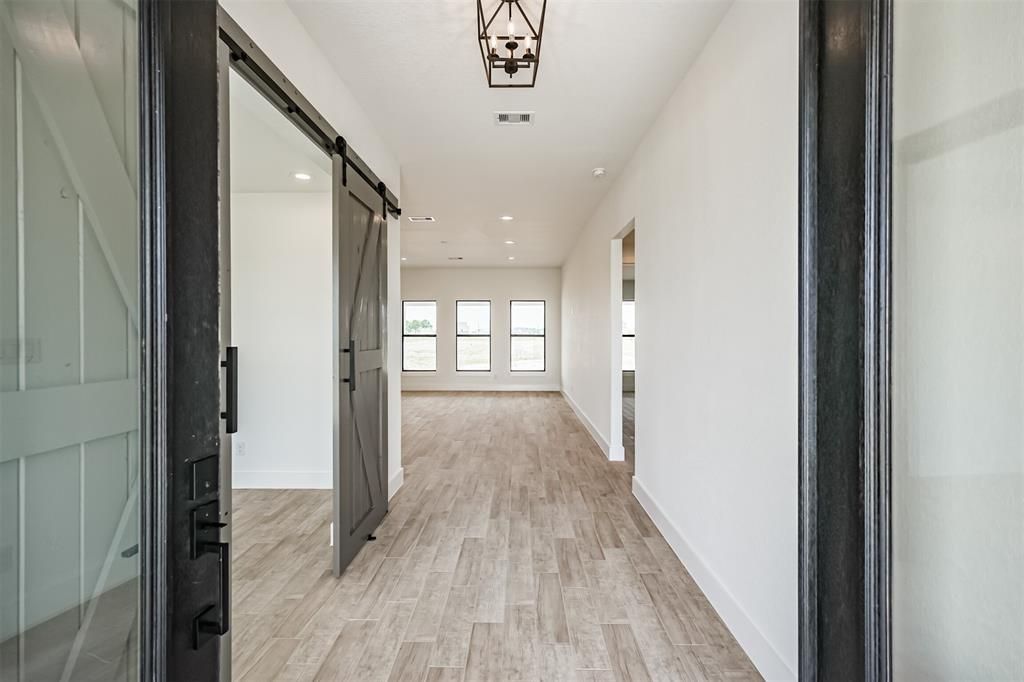 A hallway in a house with a sliding barn door.