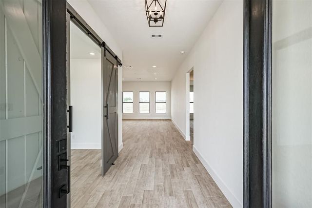 A hallway in a house with a sliding barn door.