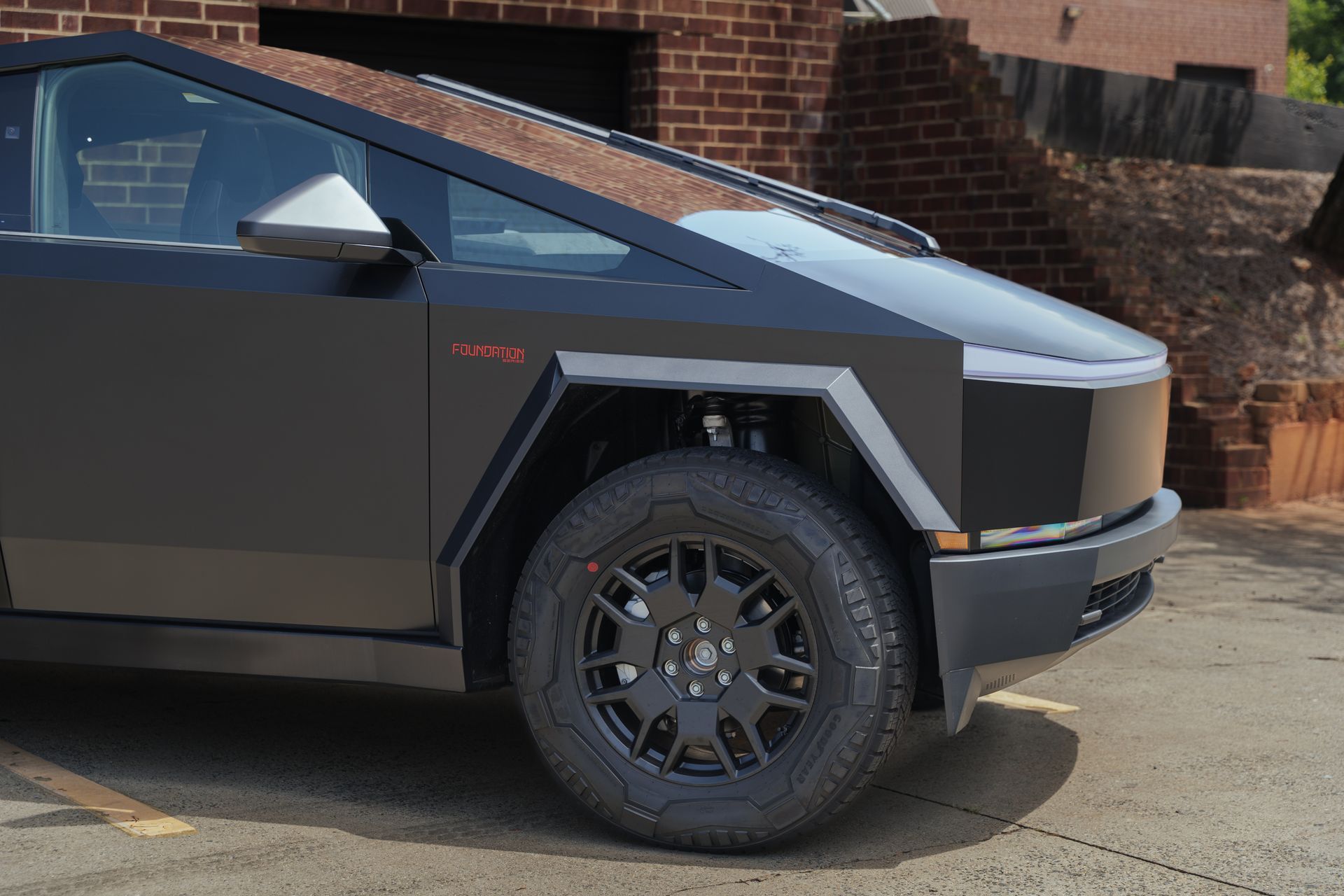 A tesla cybertruck is parked in front of a building.