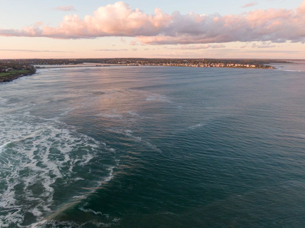 An aerial view of a large body of water at sunset.