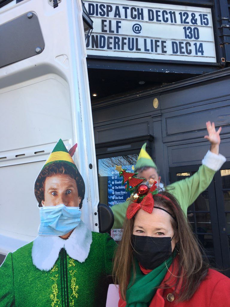 A woman wearing a mask is standing next to a man dressed as an elf.