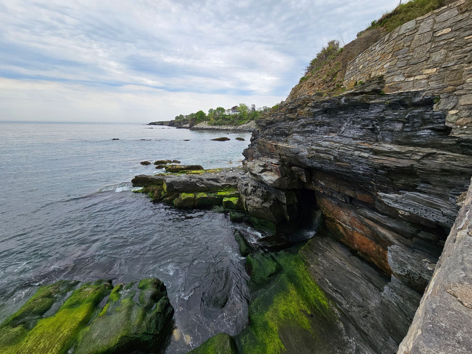 A cliff overlooking a body of water with rocks covered in moss. Understanding different grieving styles