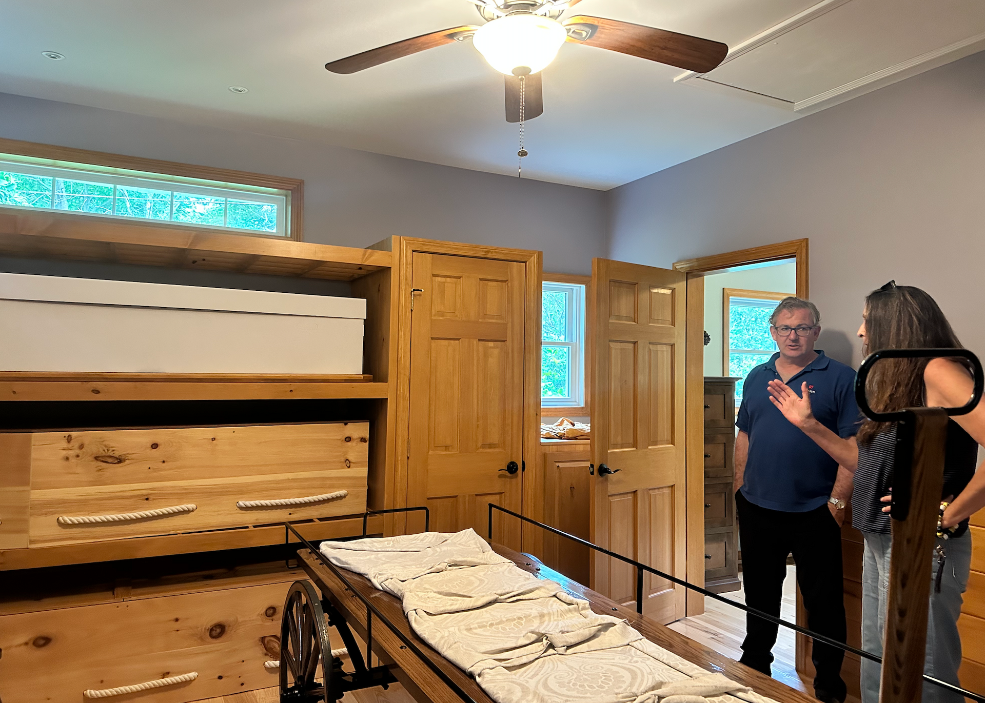 A photo of two people talking with coffins in the foreground. 