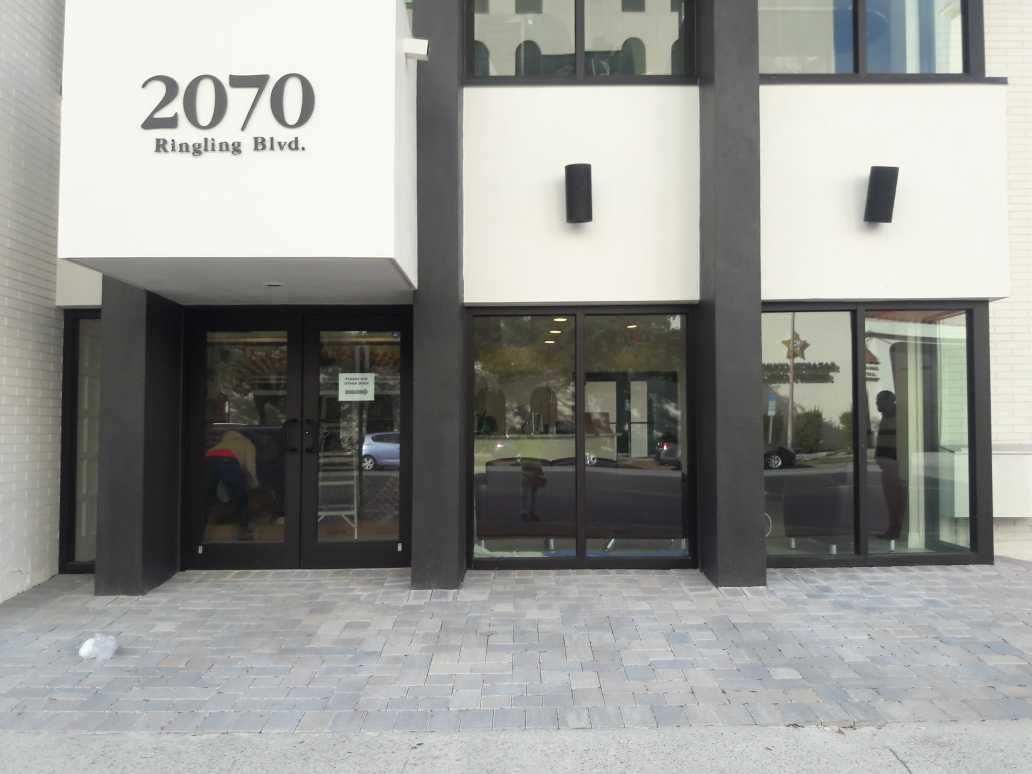 Building entrance at 2070 Eighth Blvd with glass doors and windows under a white facade.