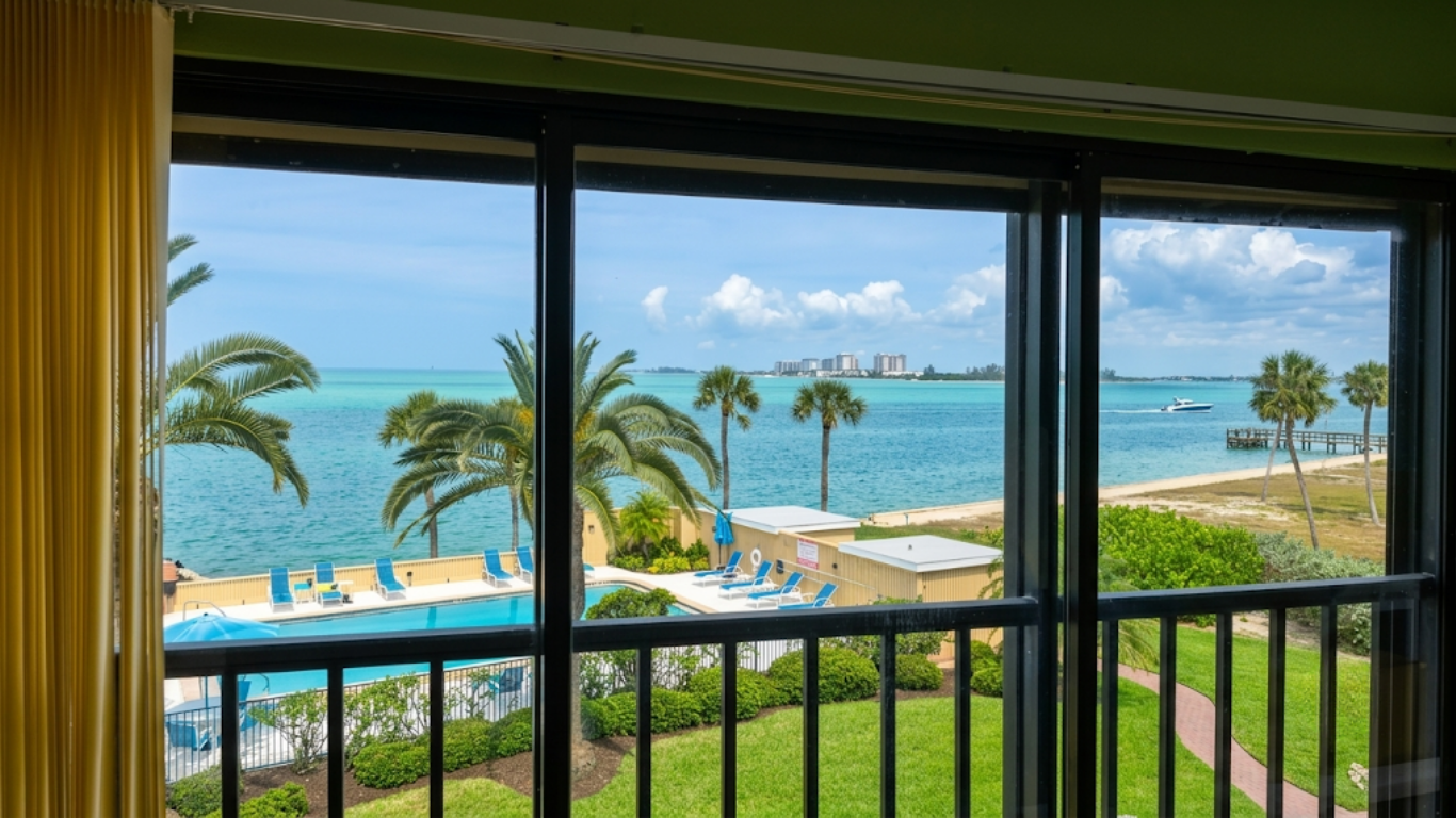 Sunroom with tall windows and a view of houses and greenery outside