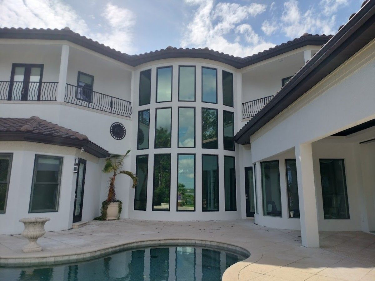 Modern white villa with arched windows and a turquoise pool in the courtyard