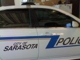 Sarasota police car with white and blue livery, partially visible side view