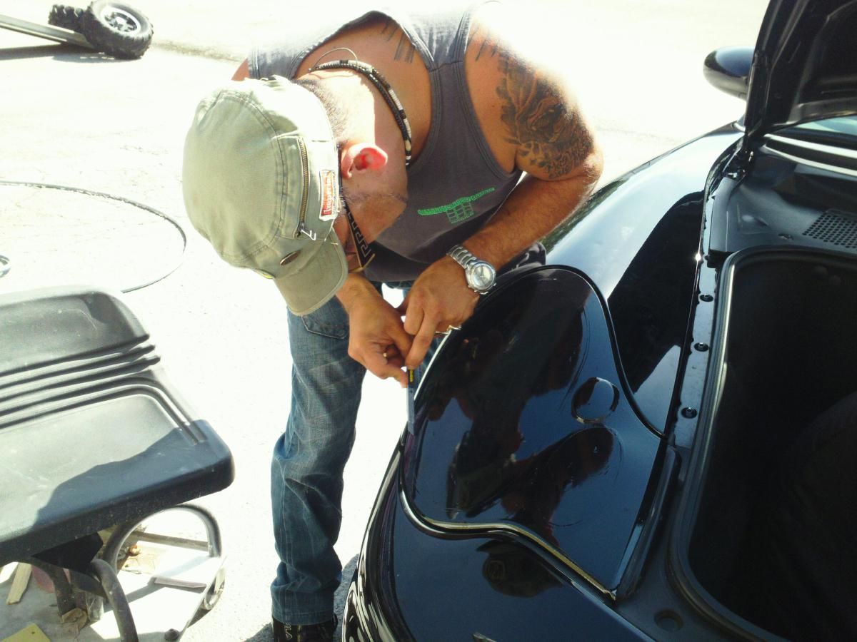 Person refueling a black car at a gas station