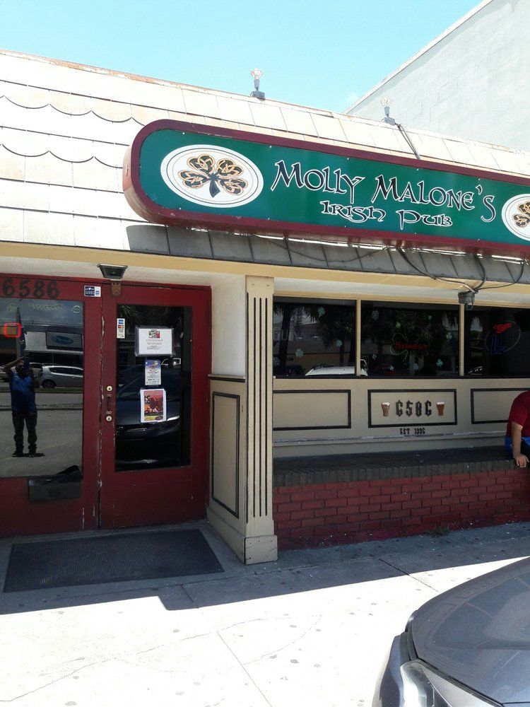 Mexican restaurant storefront with teal sign, red trim, and a sidewalk entrance