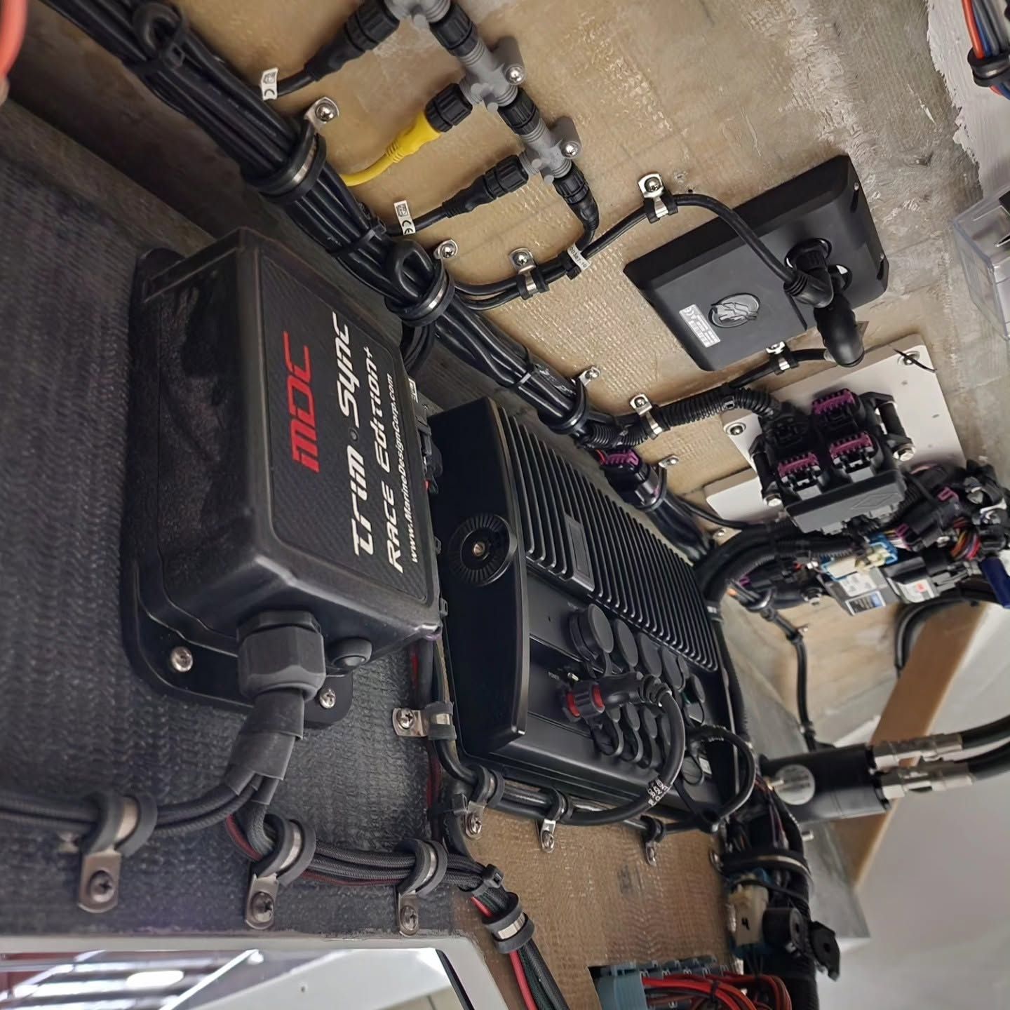 Electric wheelchair and mobility equipment arranged in a garage workspace, with tools and cables nearby.
