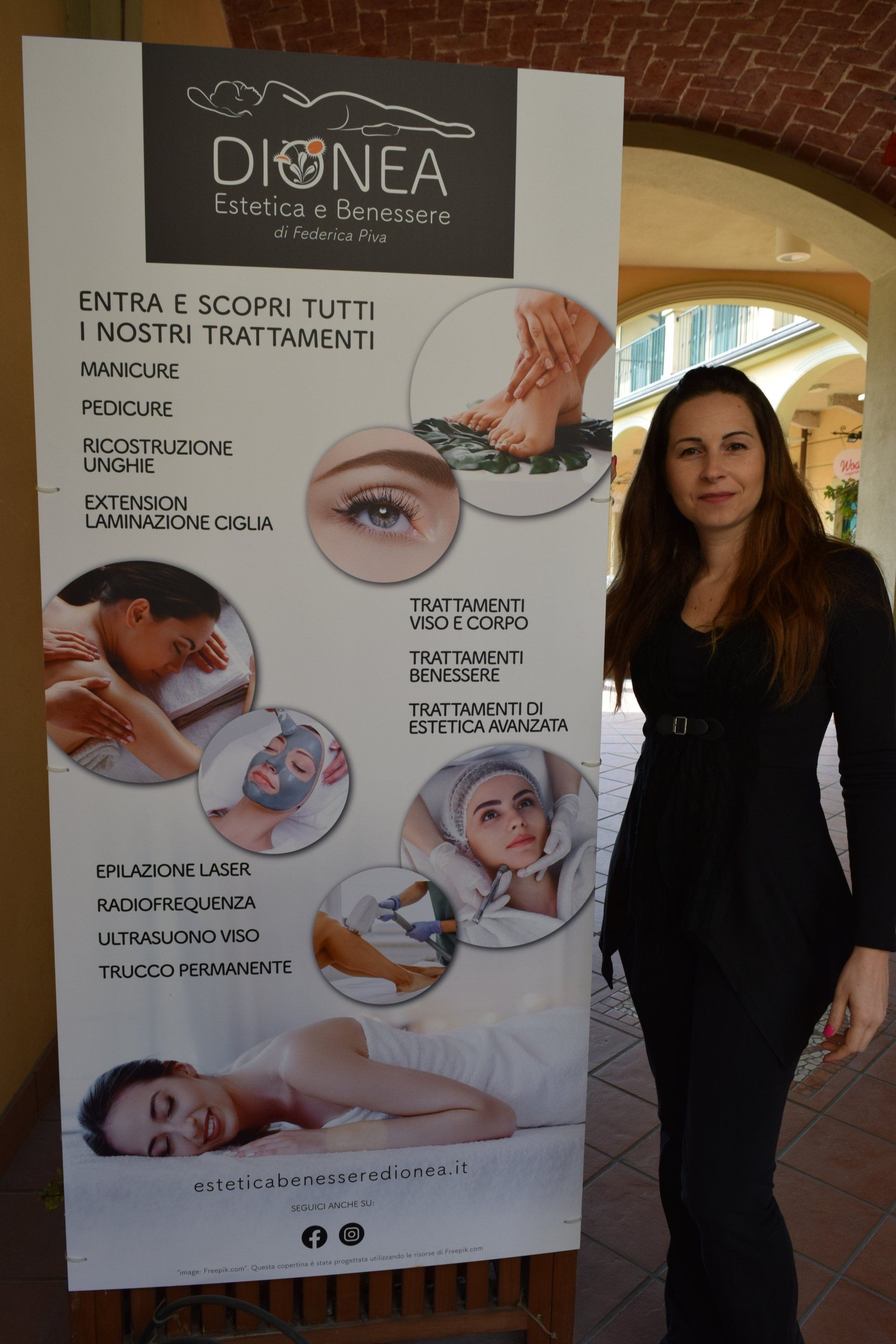 Una donna è in piedi accanto a un cartello che pubblicizza servizi di spa, su cui sono esposti vari trattamenti di bellezza.