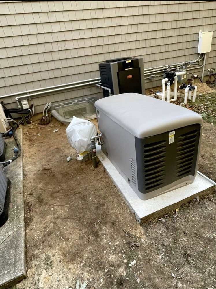 Outdoor home generator and connected components on a concrete pad next to a house.