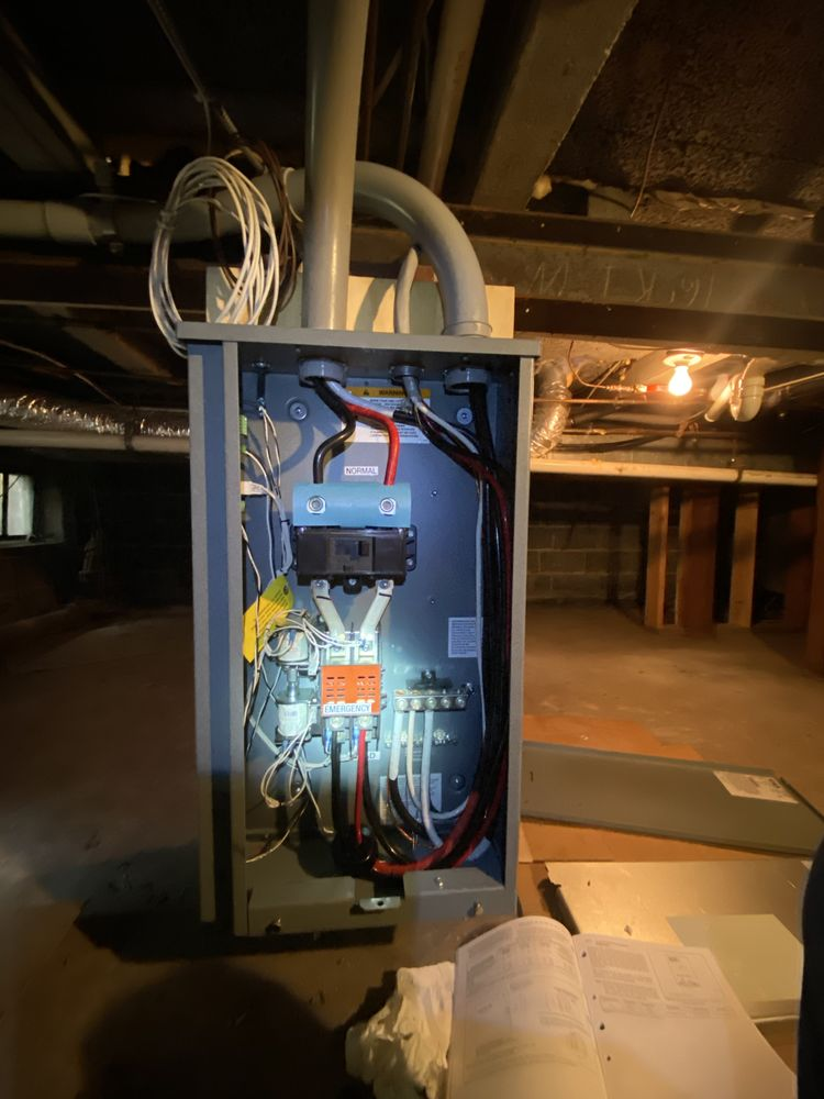 Open electrical panel in a basement, with wires, breakers, and conduits.