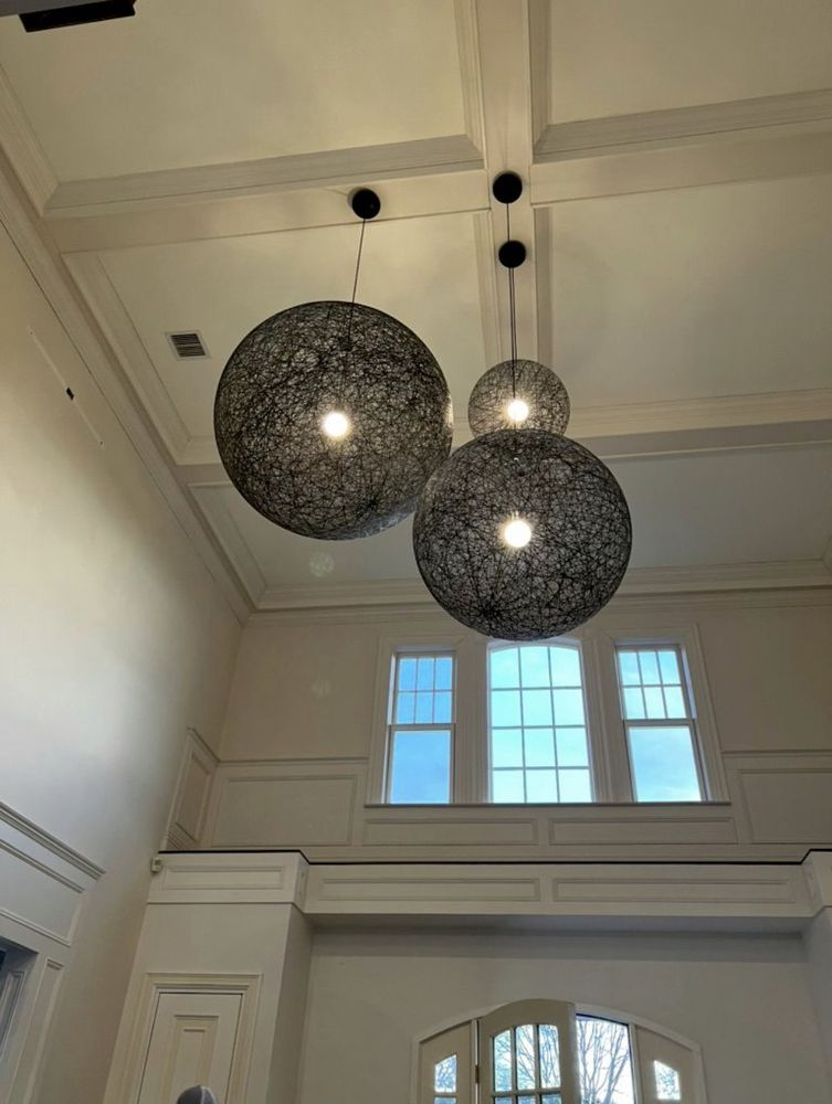 Three black sphere pendant lights hang from a white coffered ceiling.