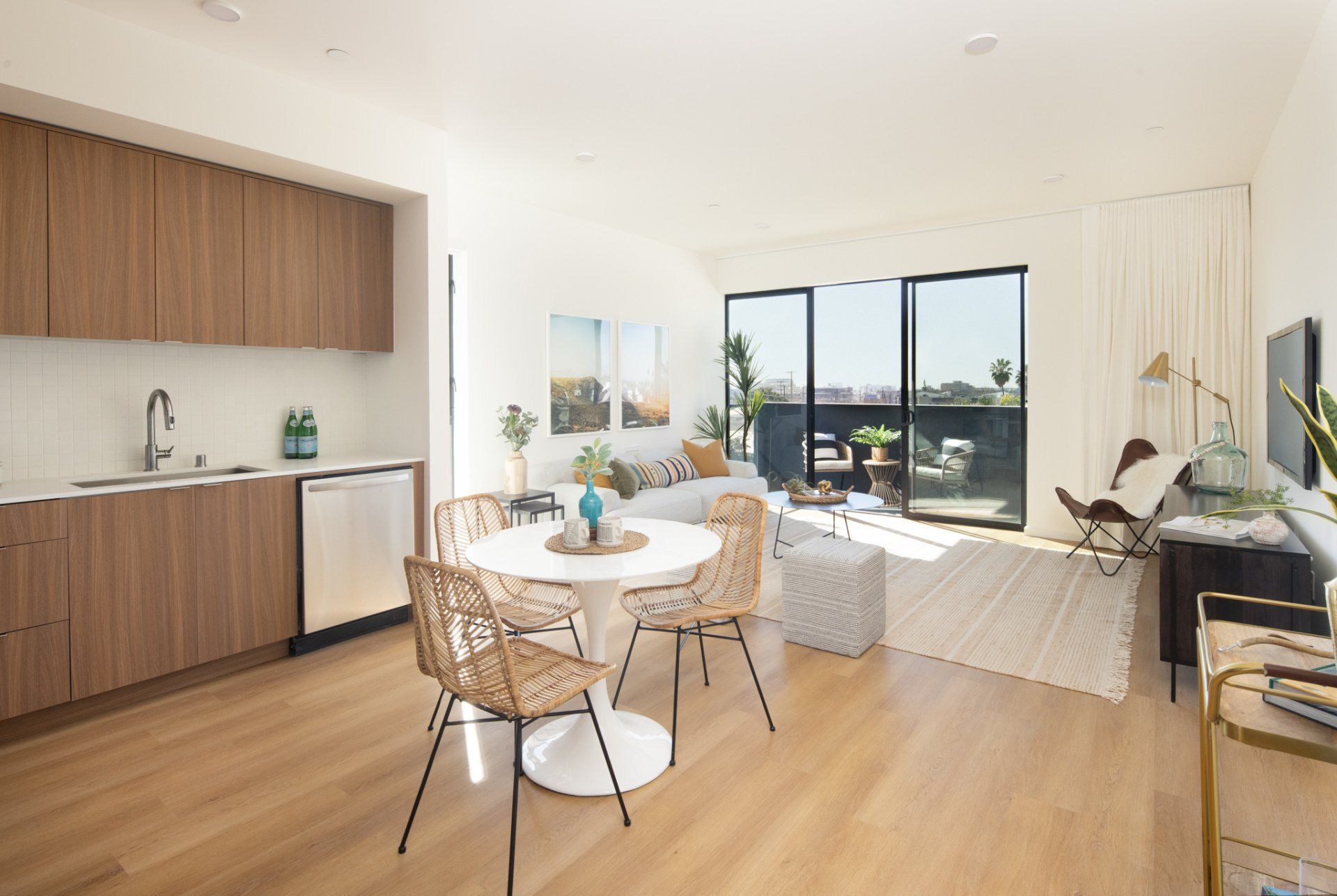 Bright dining and kitchen area with wood cabinetry and large windows in Frame Downtown Culver City