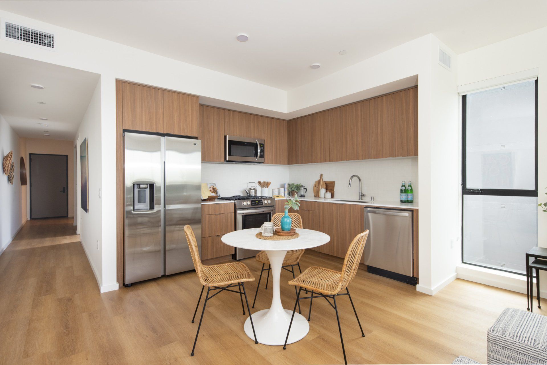 Bright dining and kitchen area with wood cabinetry and large windows in Frame Downtown Culver City