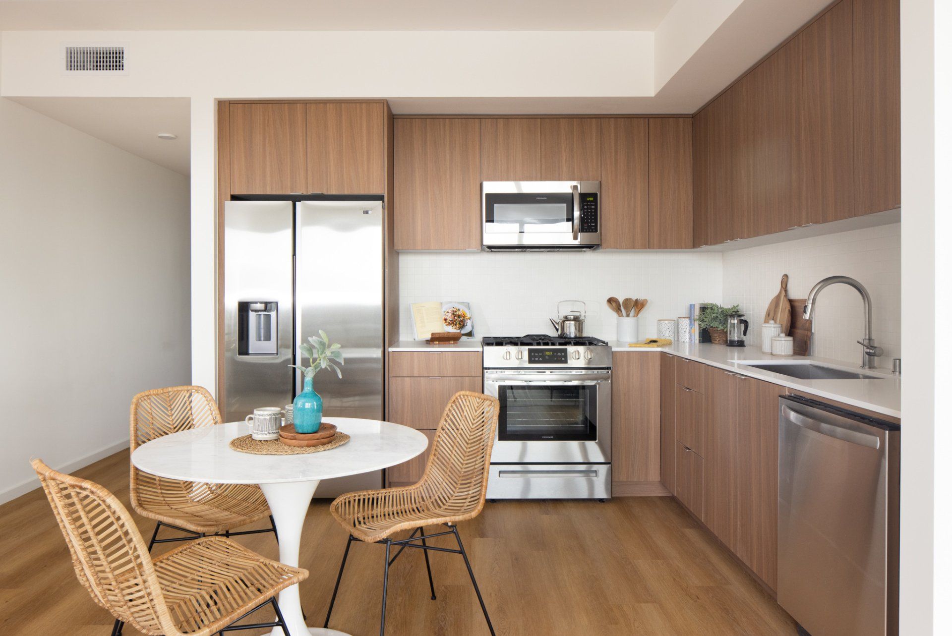 Bright dining and kitchen area with wood cabinetry and large windows in Frame Downtown Culver City