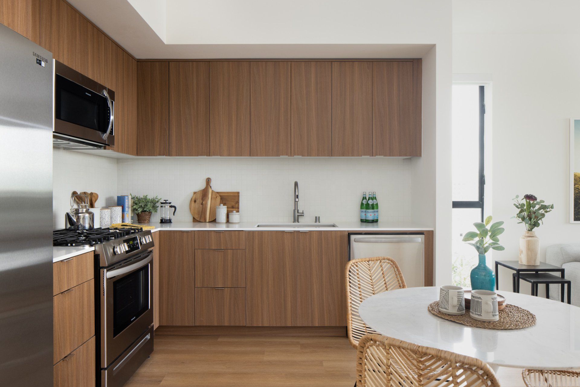 Bright dining and kitchen area with wood cabinetry and large windows in Frame Downtown Culver City