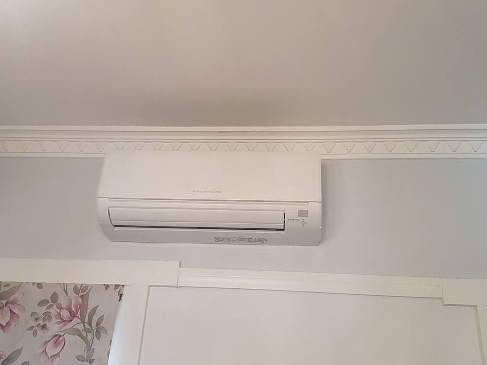 White Wall-Mounted Air Conditioner on A Pale Gray Wall — Leader Air Conditioning in Albury/Wodonga, VIC