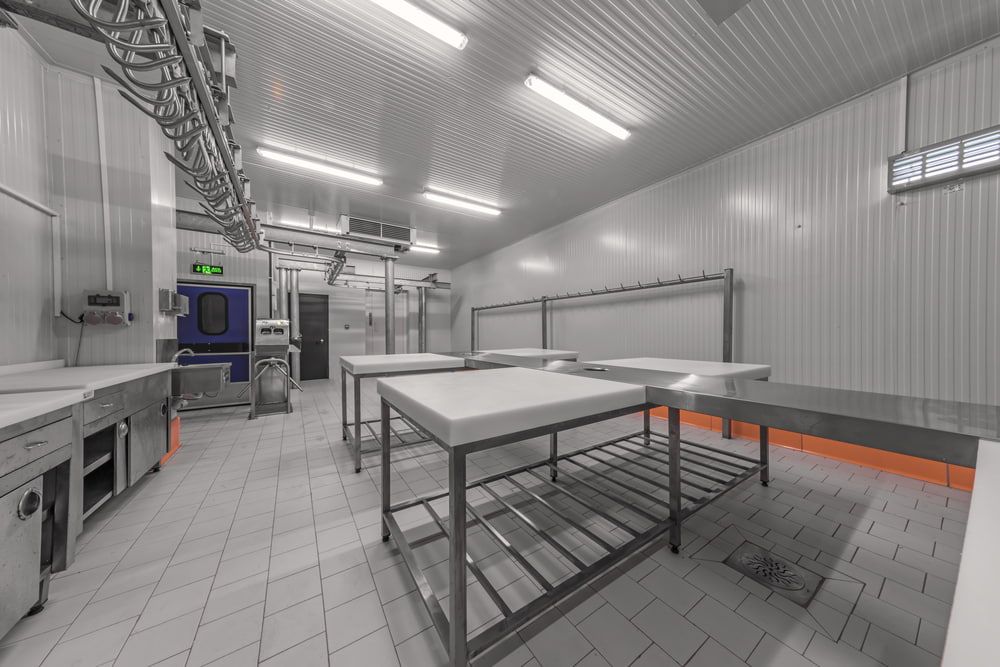 An Industrial Food Processing Room with Stainless Steel Tables — Leader Air Conditioning in Queanbeyan, NSW