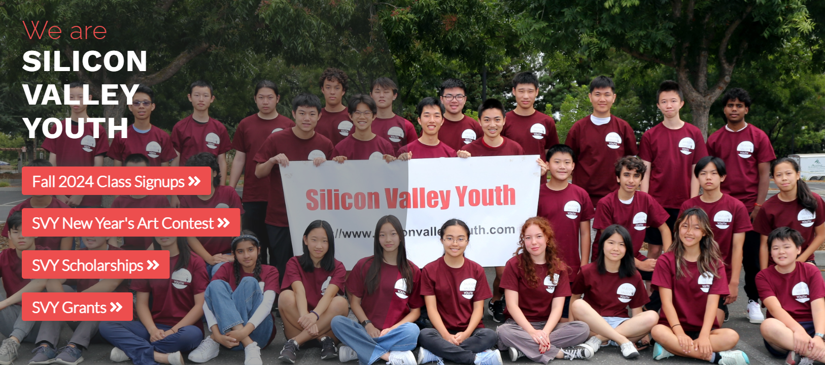 Group photo of Silicon Valley Youth volunteers in red shirts holding a banner outdoors