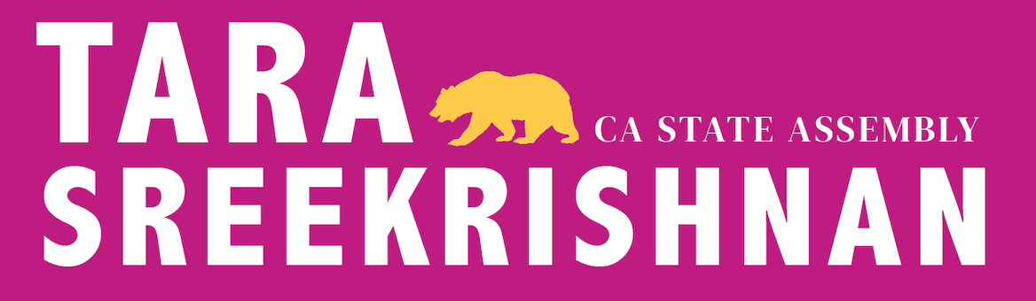 Pink campaign banner reading “TARA SREEKRISHNAN” with a yellow tiger and “STATE ASSEMBLY” text