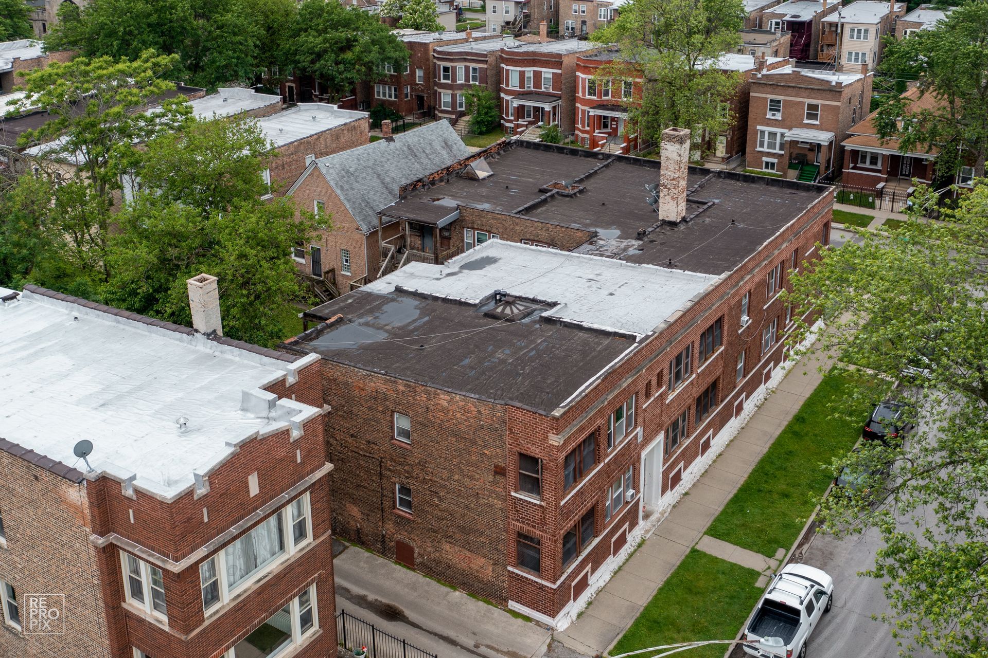 Aerial view of brick apartment buildings with flat roofs and a street in a residential neighborhood.