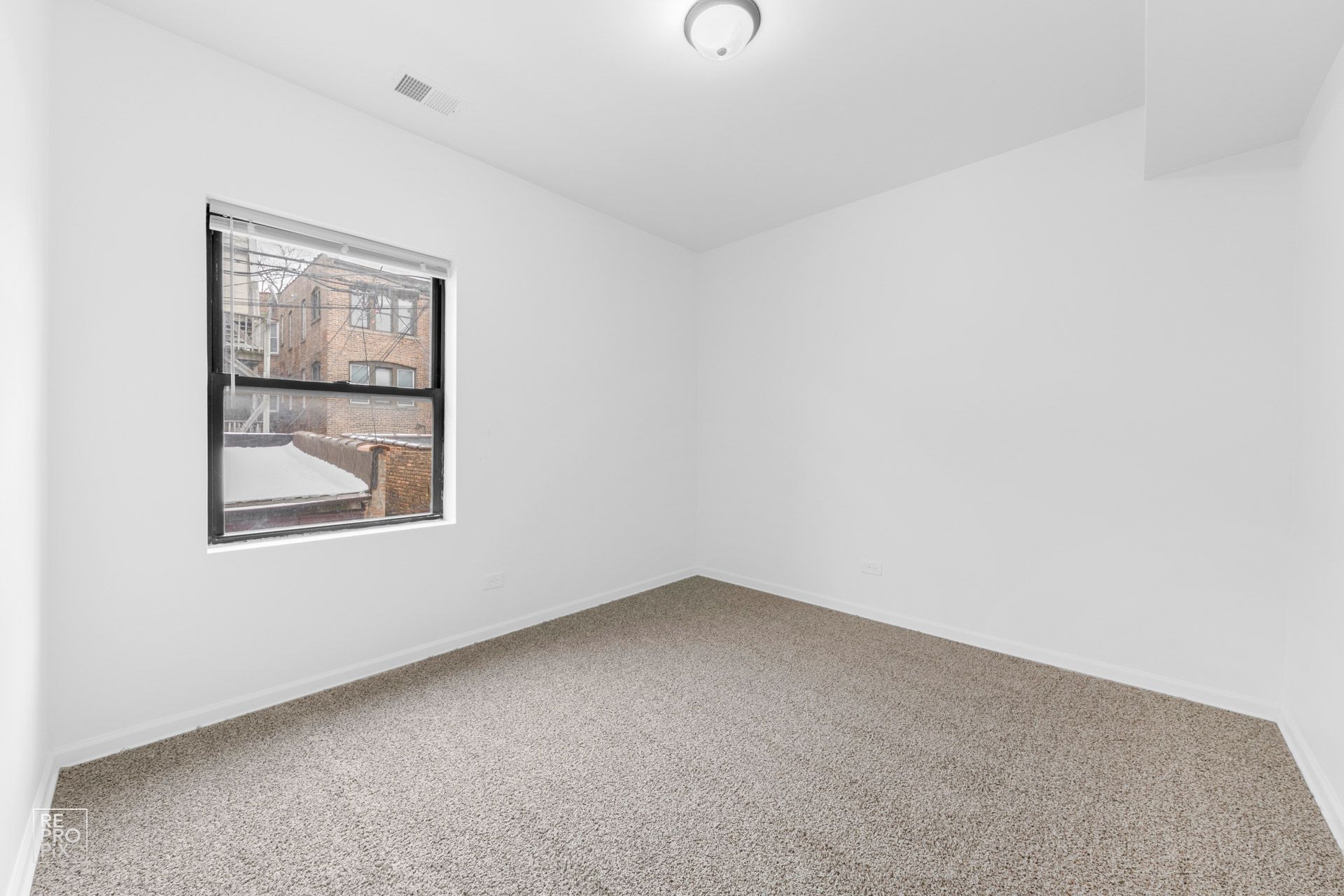 Empty room with beige carpet, a window, and white walls.