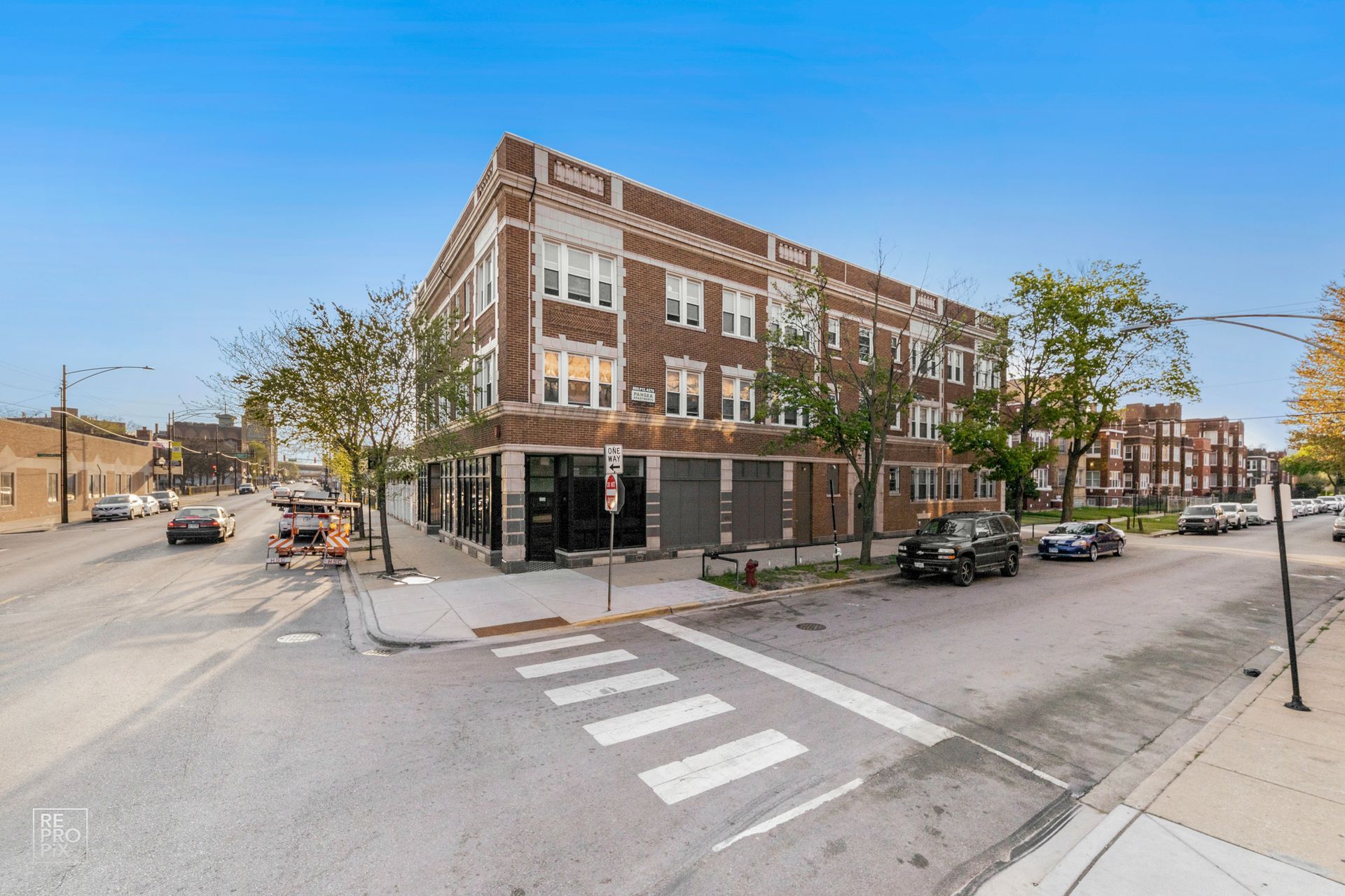 Brick apartment building on a street corner, with storefronts on the ground floor.