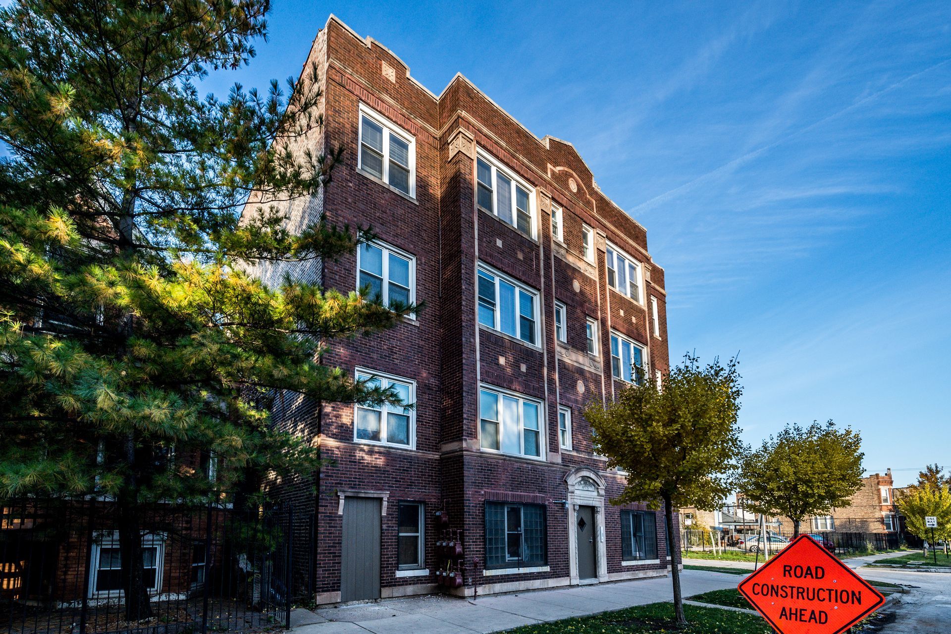 Brick apartment building with blue sky. Street sign: