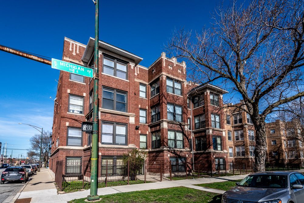 Brick apartment building on a sunny day with street sign that reads